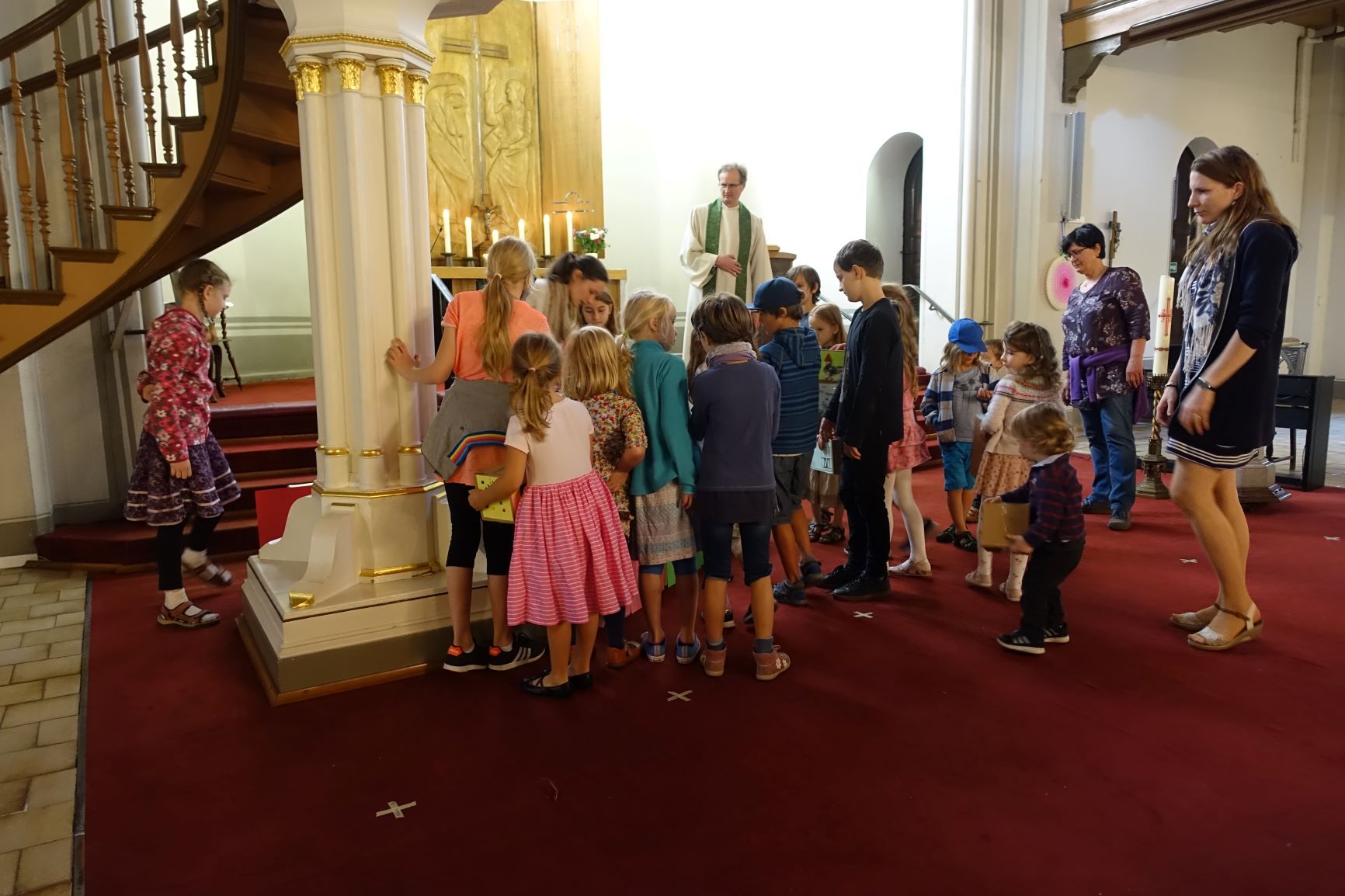Kinder mit Pastor und Helferinnen vor dem Altar